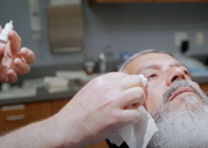 cataract surgeon showing pateint how to use eye drops after surgery